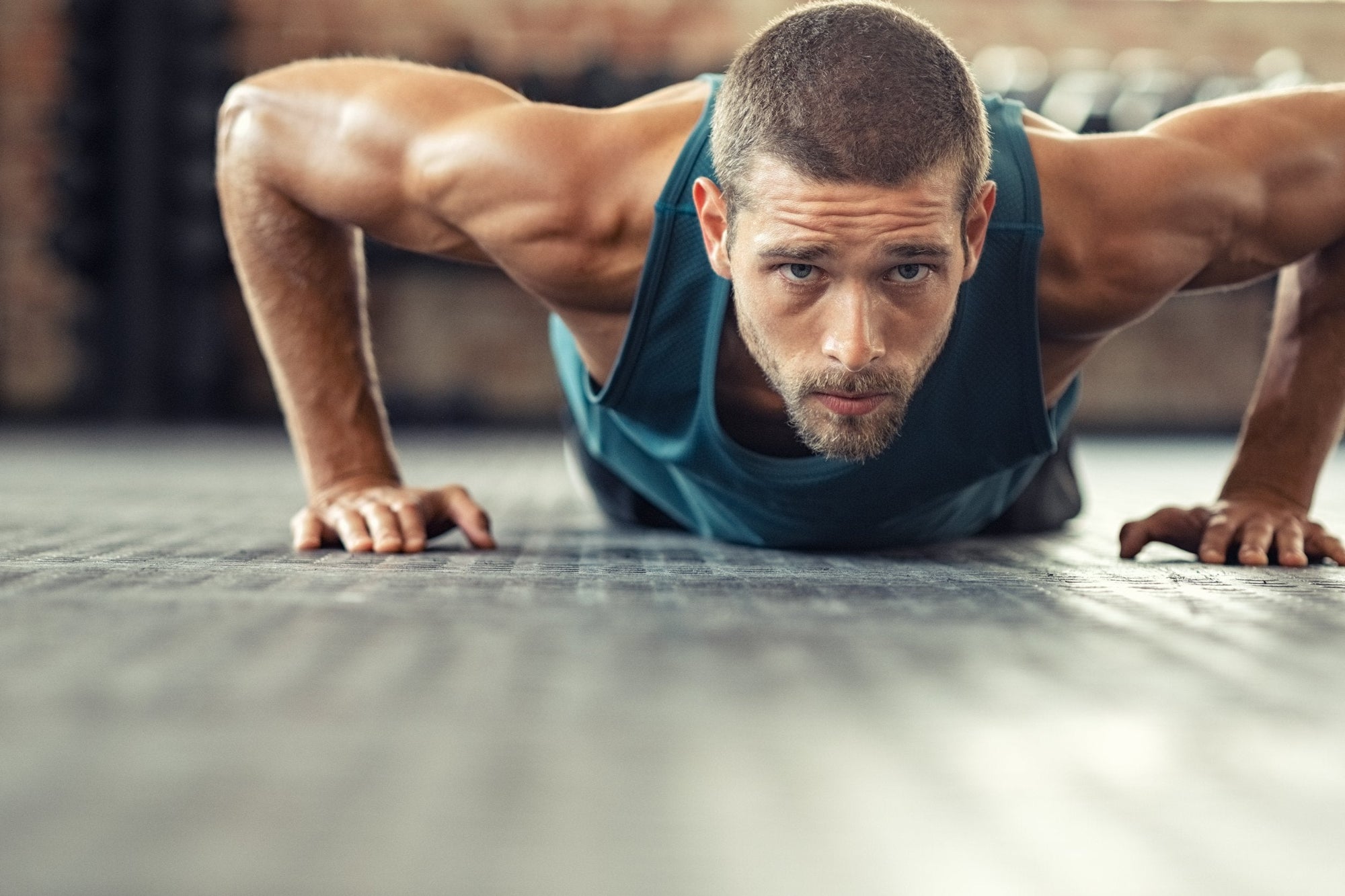 Young and muscular man is doing push-ups during calisthenic workout on a street