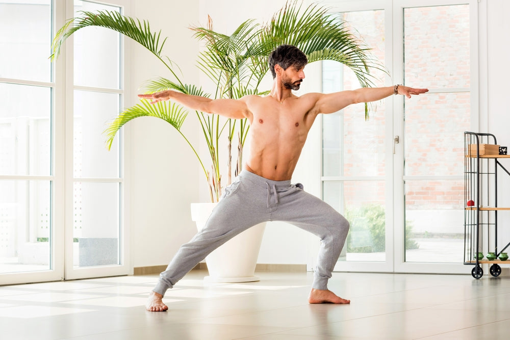 Fit muscular flexible man posing in difficult yoga pose Stock Photo