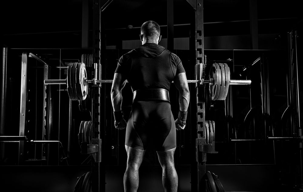 A man standing in front of a squat rack