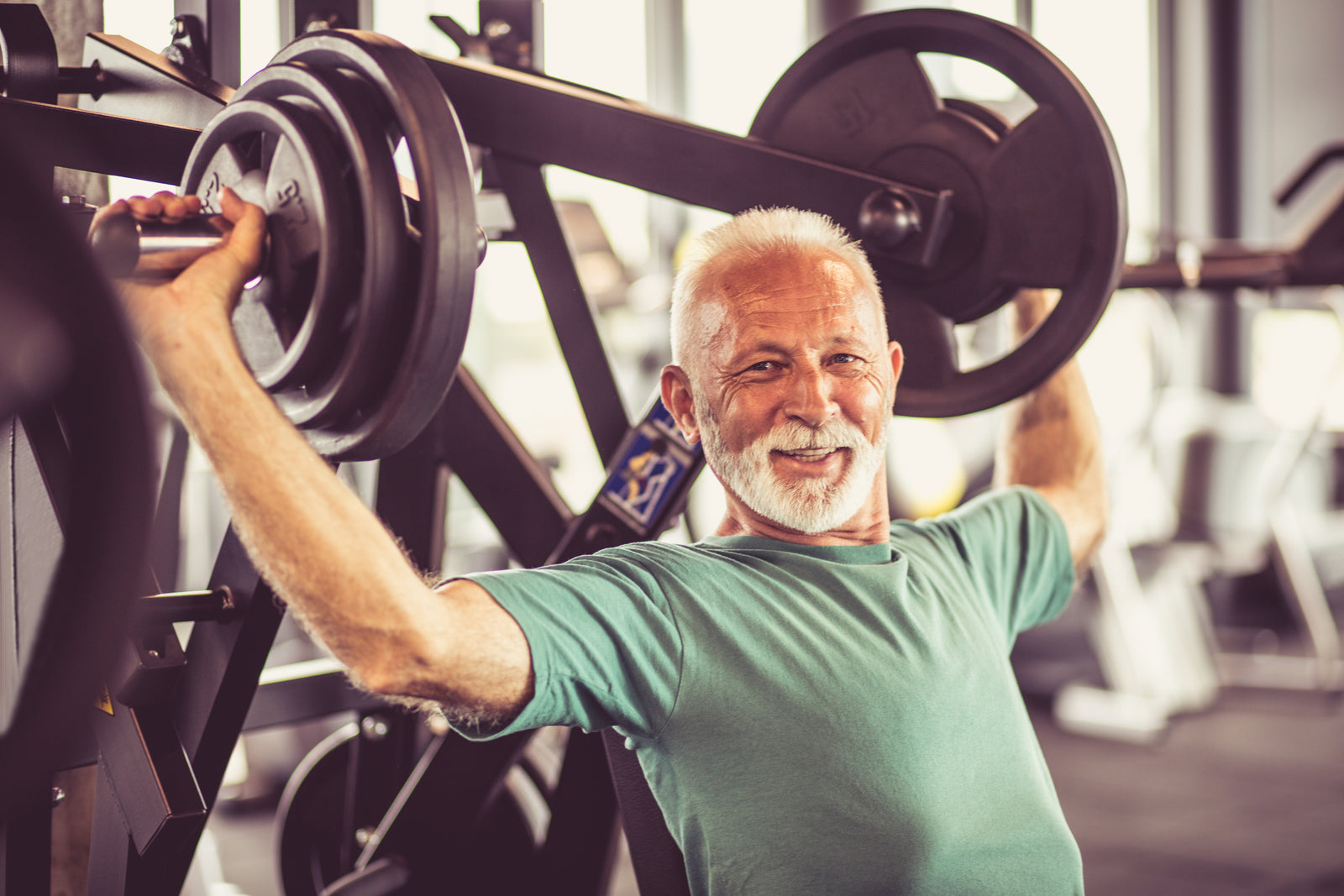 Foto de Female middle age fitness model shows muscular and lean arm  strength while performing a dumbbell curl in gym. do Stock