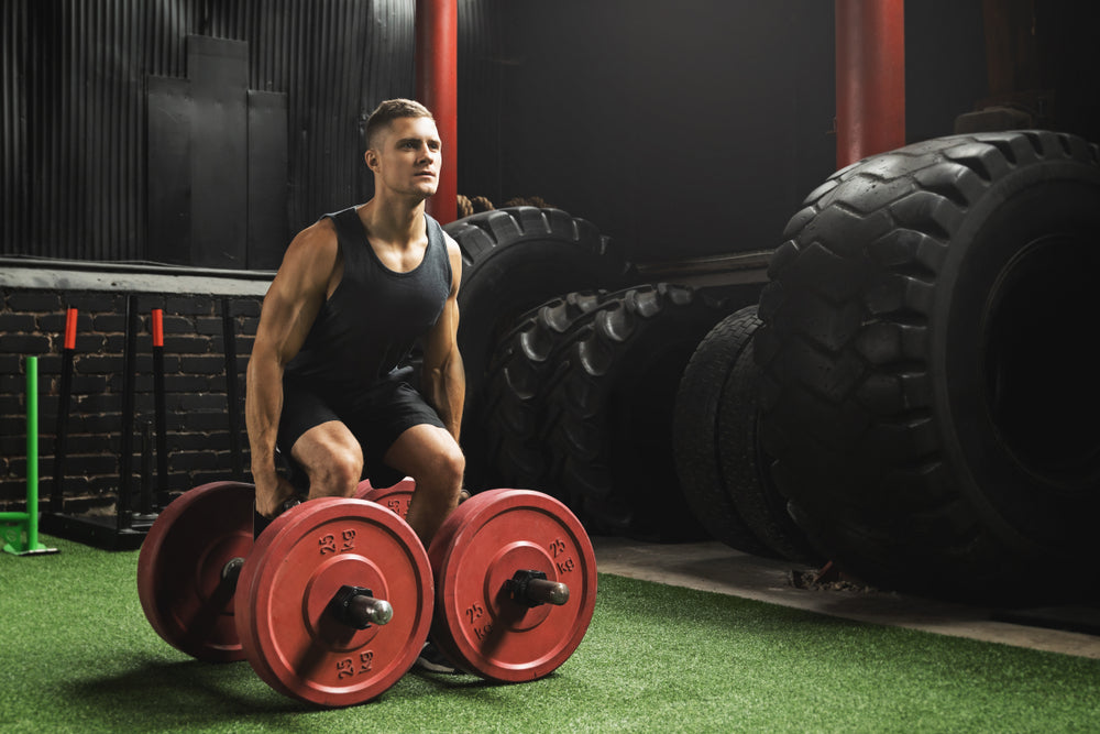 Young muscular sportsman doing farmer's walk exercise