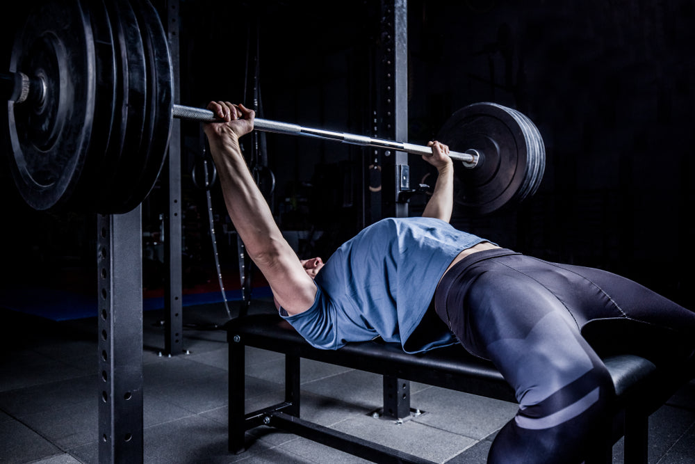 Man In Gym Exercising On The Barbell Bench Press