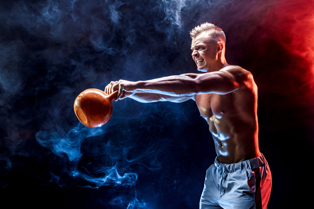 strong fit muscular bodybuilder doing kettlebell swings