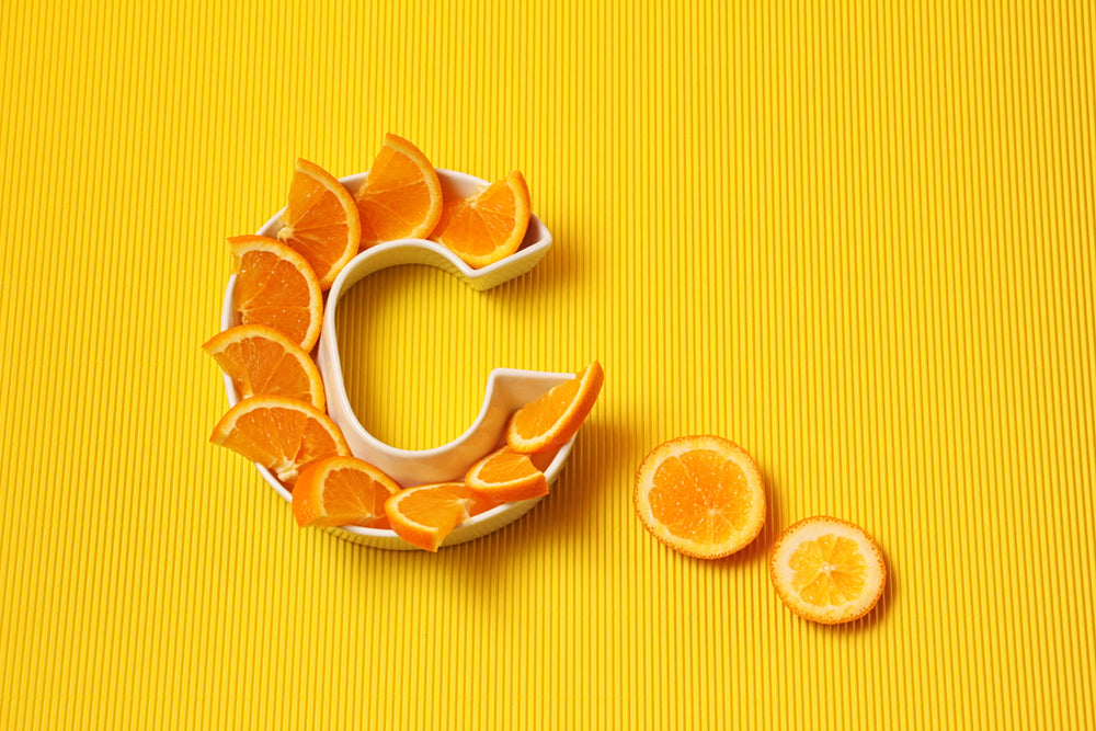  Plate in shape of letter C with orange slices on bright yellow background.