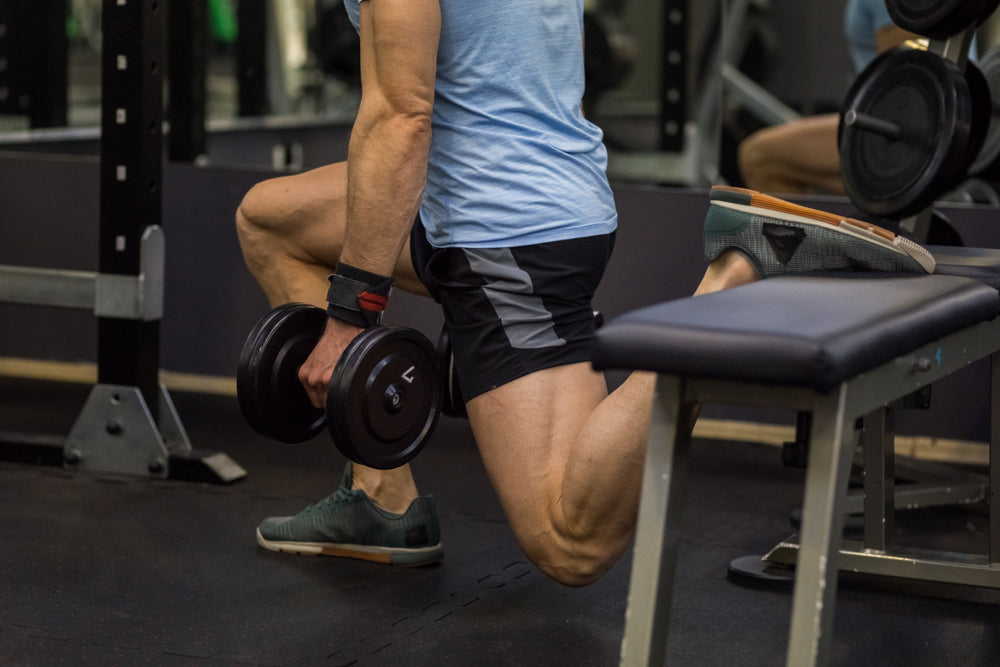 Attractive man doing lunges step-ups with heavy dumbbell.
