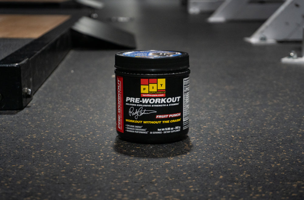 A pre workout container sits on the gym floor. 