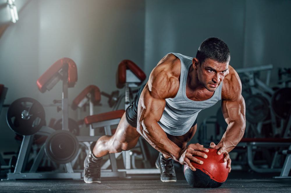 Athletic Man doing push ups on the Medicine Ball