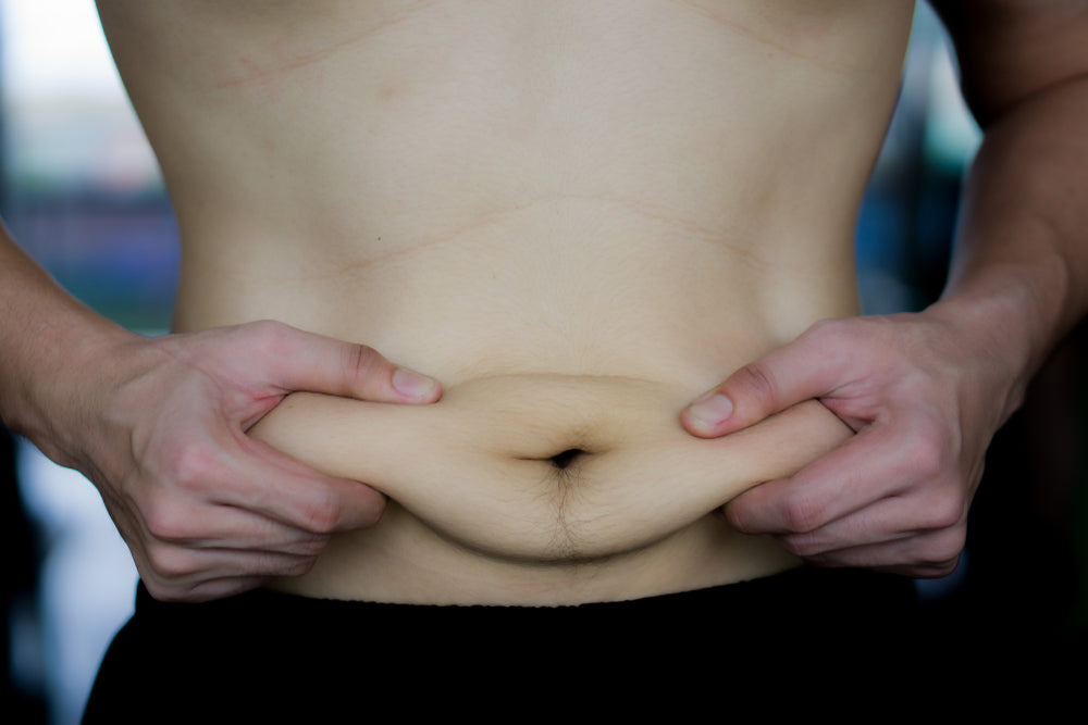 Close up man holding excessive fat belly