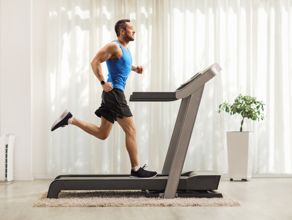 young man running on a treadmill at home 
