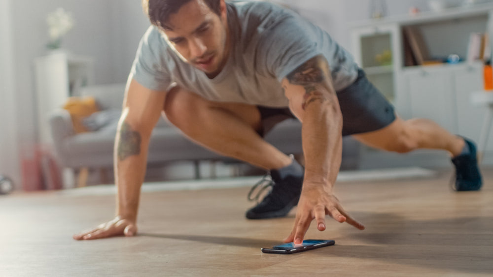 Muscular Athletic Fit Man in T-shirt and Shorts Doing Mountain Climber Exercise