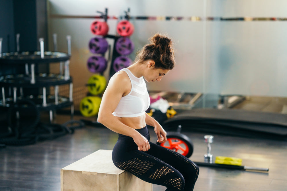 Athletic woman doing squats on box as part of exercise routine