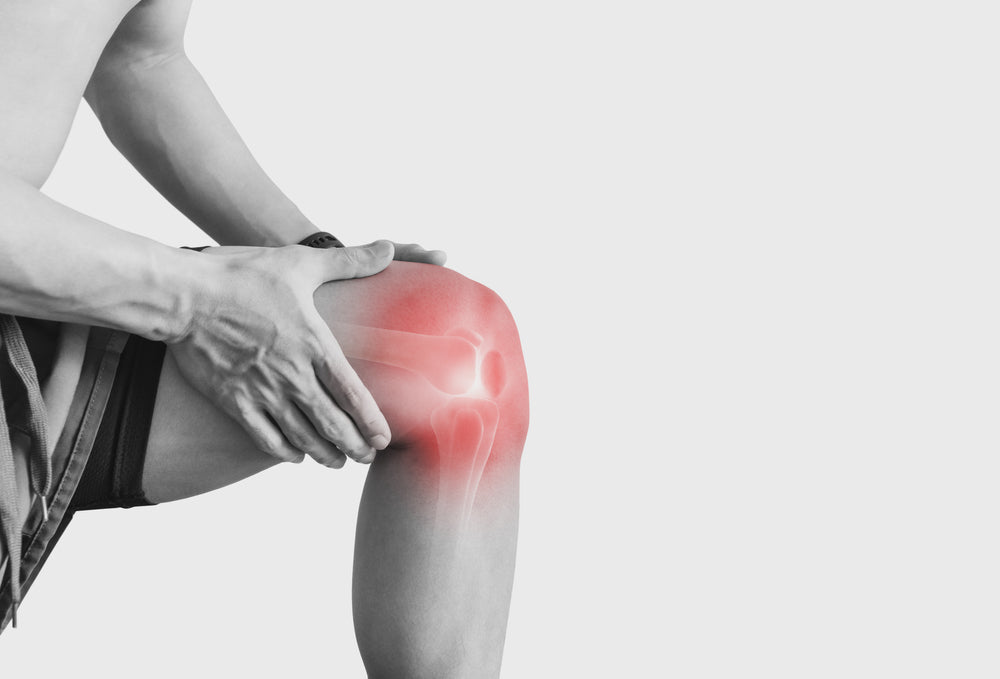 a man touching knee at pain point