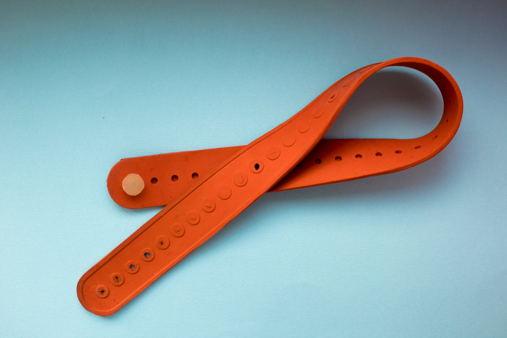 medical tourniquet orange on a blue background.