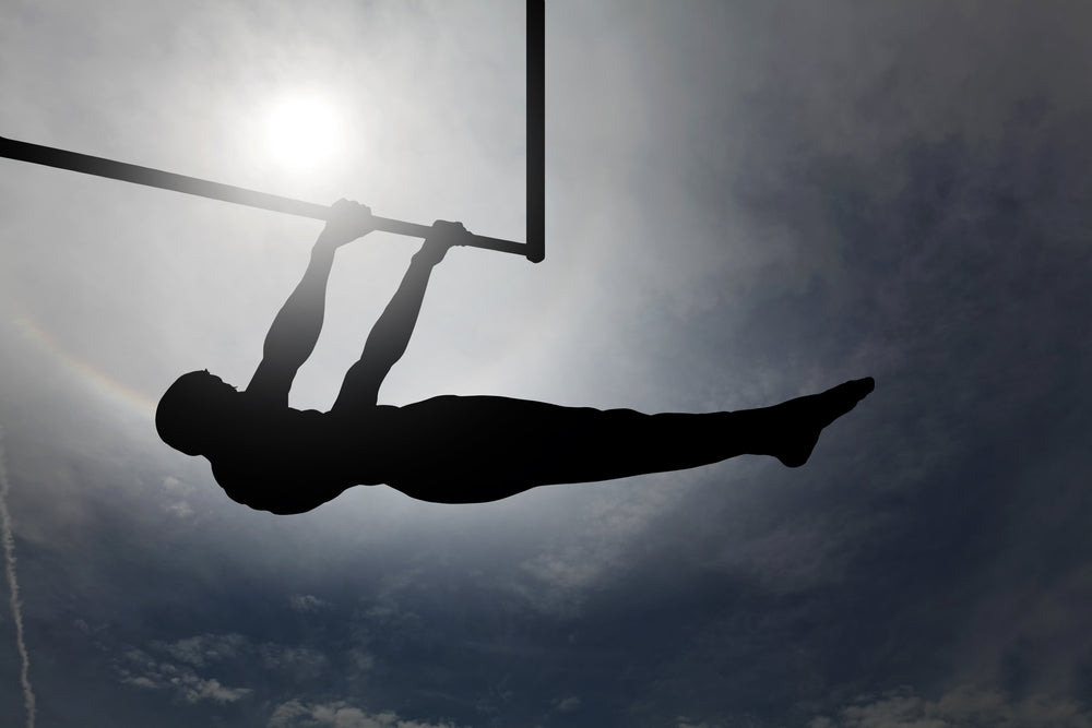 Silhouette of a man doing a front lever.