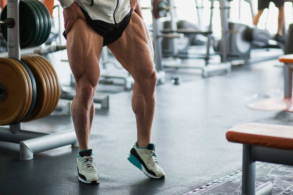 Handsome young muscular Caucasian man of model appearance working out in the gym training legs 