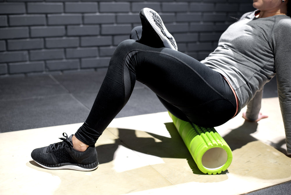 young woman massage butt on the foam roller