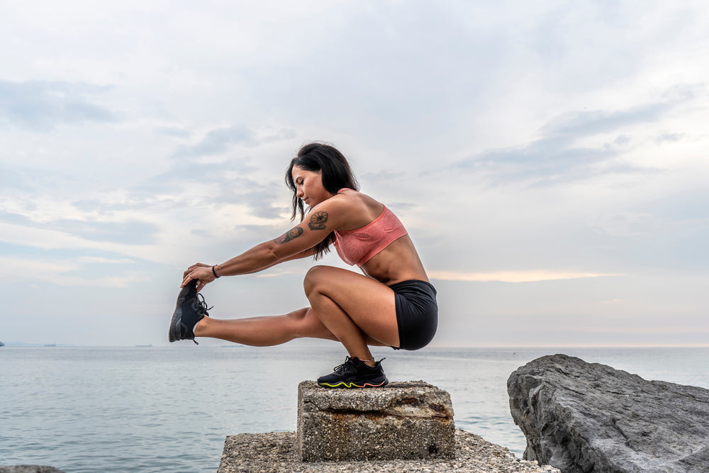 Fitness woman doing pistol squat outdoors