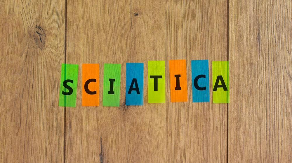 oncept word 'sciatica' on colored papers on a beautiful wooden background