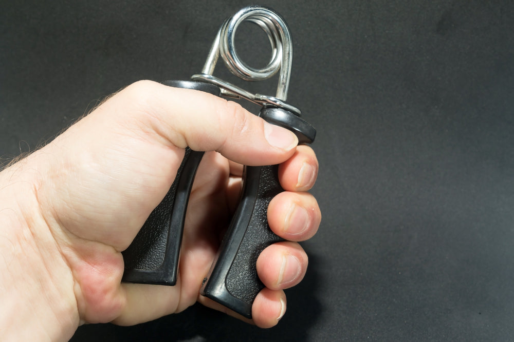 man hand using exercise tool for hand wrist and forearm on black background