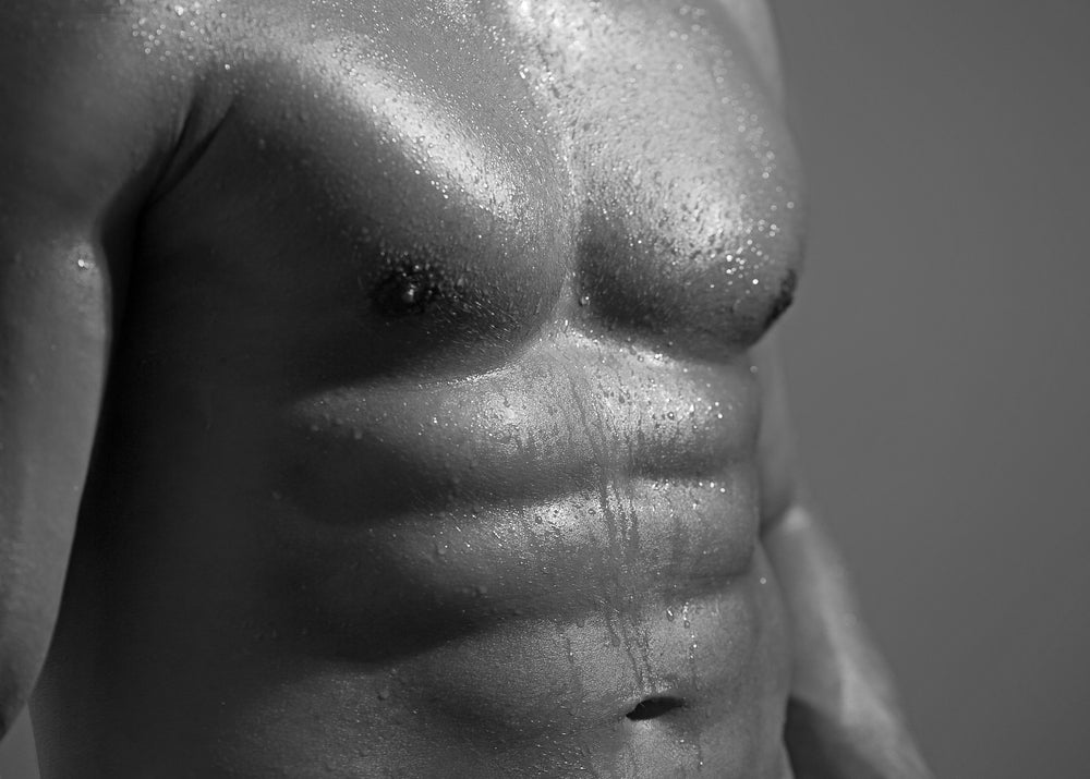 bodybuilder in cap on stone wall background