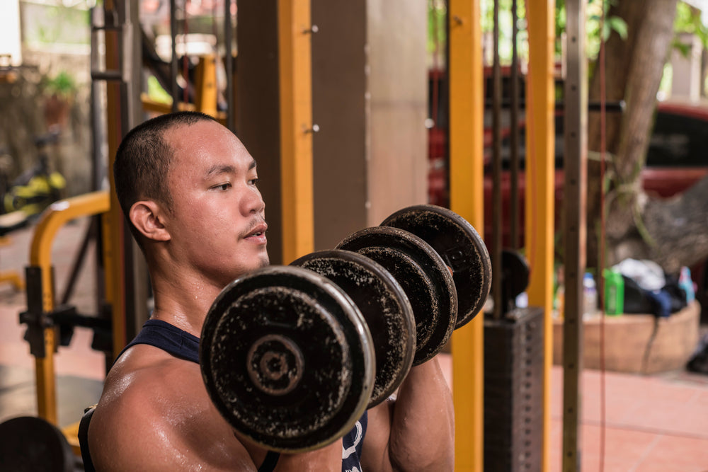 Closeup of a fit Filipino guy doing Seated Arnold Shoulder Presses