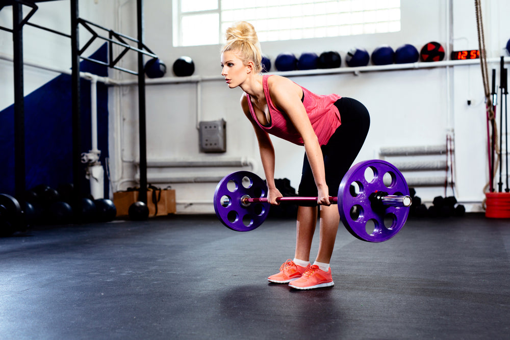 Young woman training Straight Leg Deadlift exercise at gym