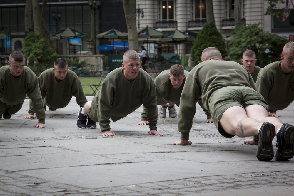 A group of US Marines doing push ups during an early morning boot camp exercise in Bryant Park at Marine Day during Fleet Week NY 2015