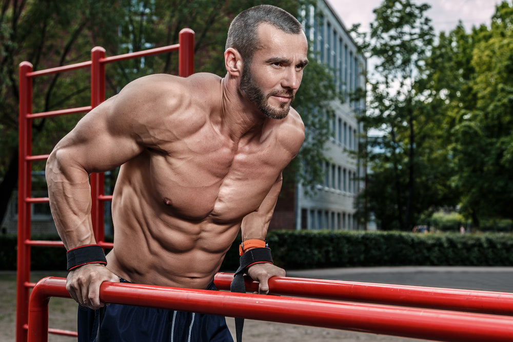 Muscular man during his workout on the street