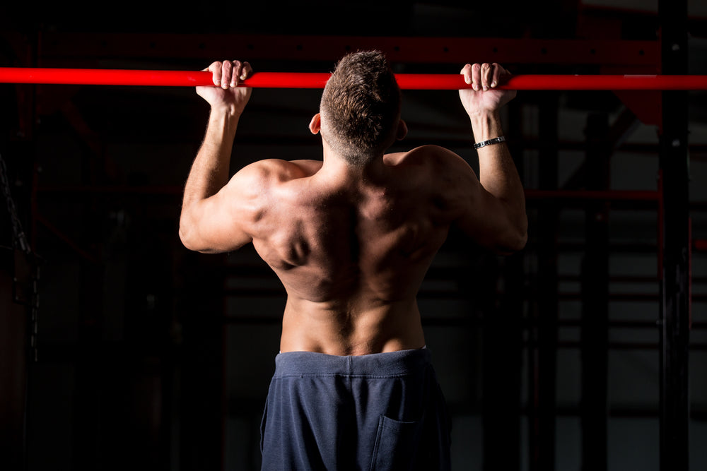 caucasian sportsman working out in gym, exercising on chin-up bar