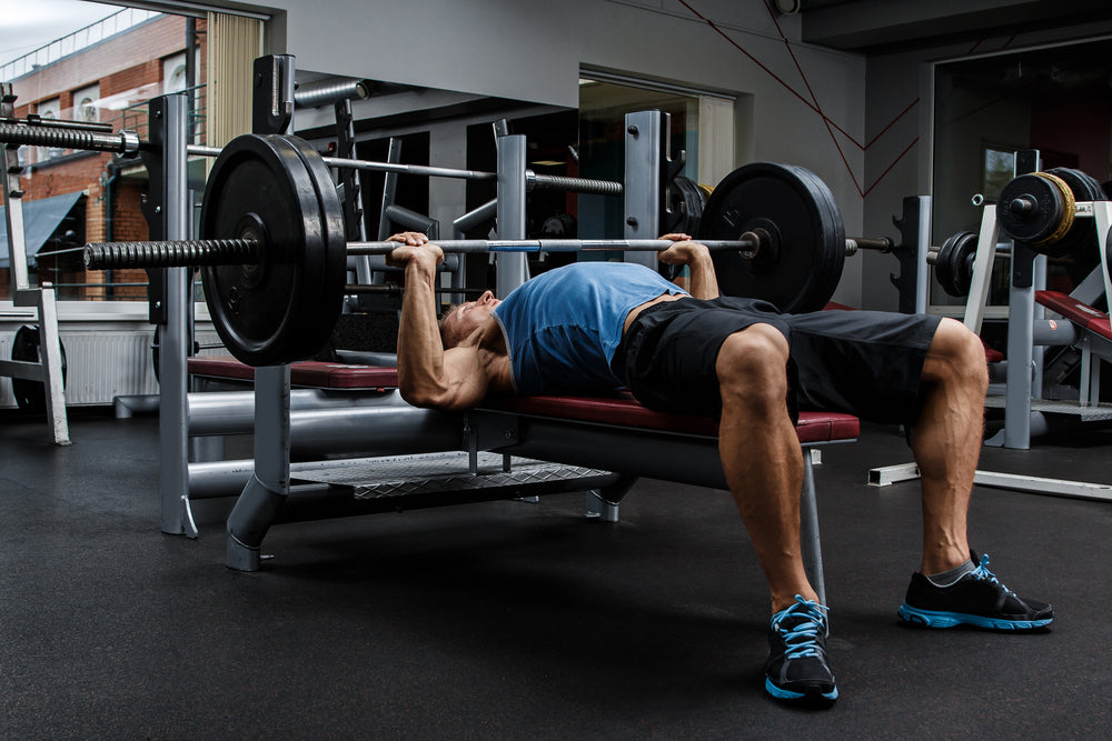 Man doing bench press exercise in gym.