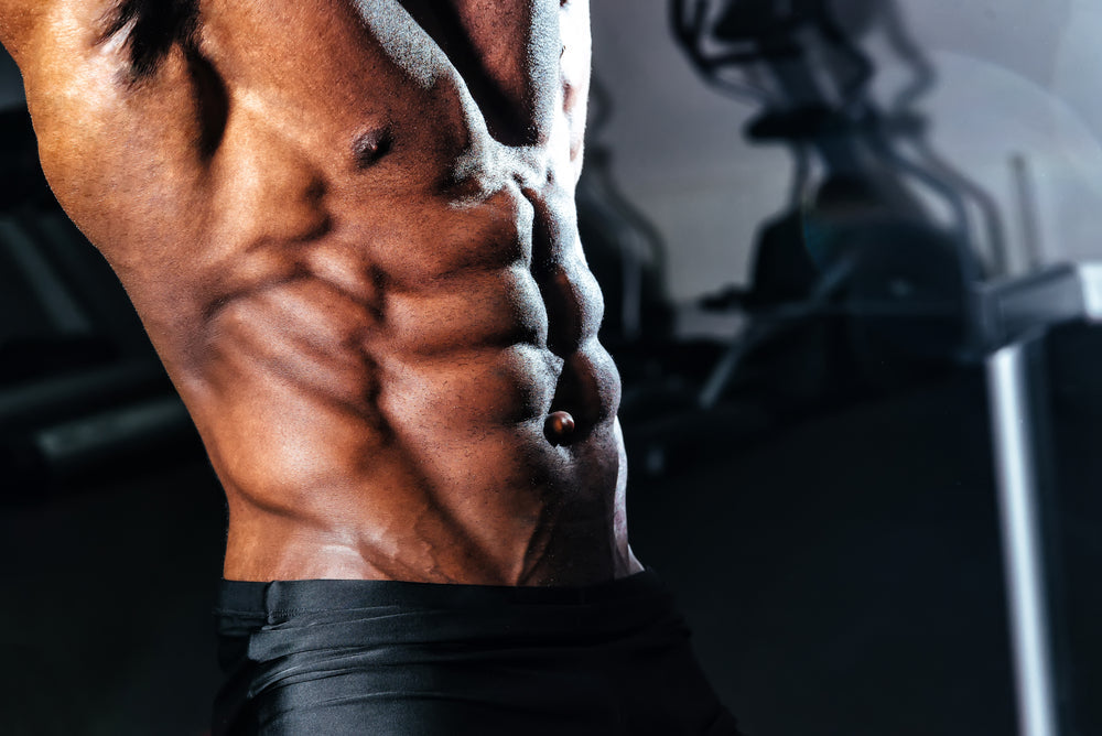 man showing off lean and defined six pack abs