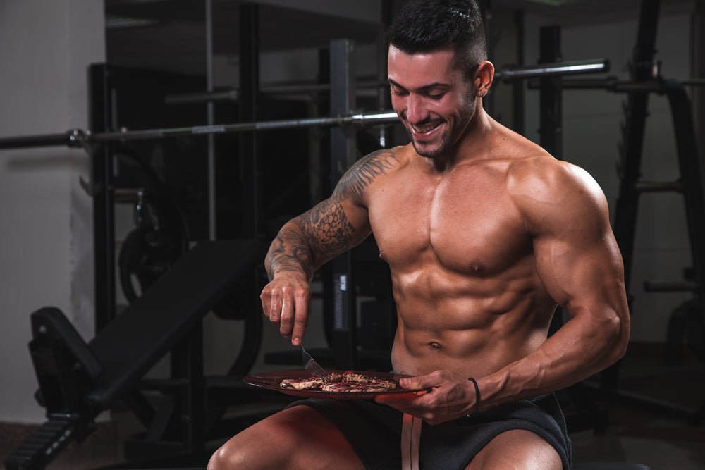 Fit muscular man eating clean in the gym.