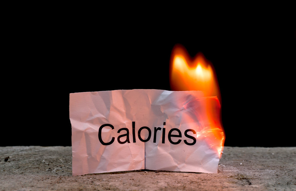 Burning paper with word calories written on it