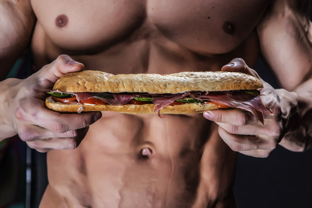 bodybuilder holding a submarine sandwich