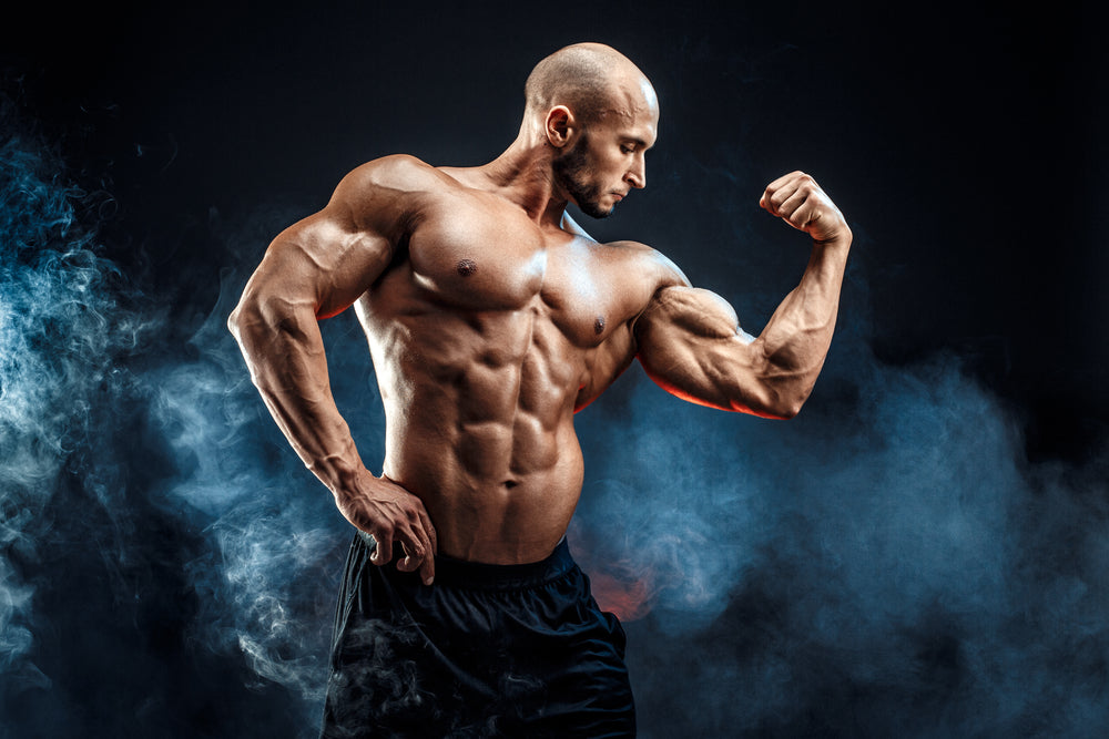 Strong bald bodybuilder with six pack abs flexing biceps