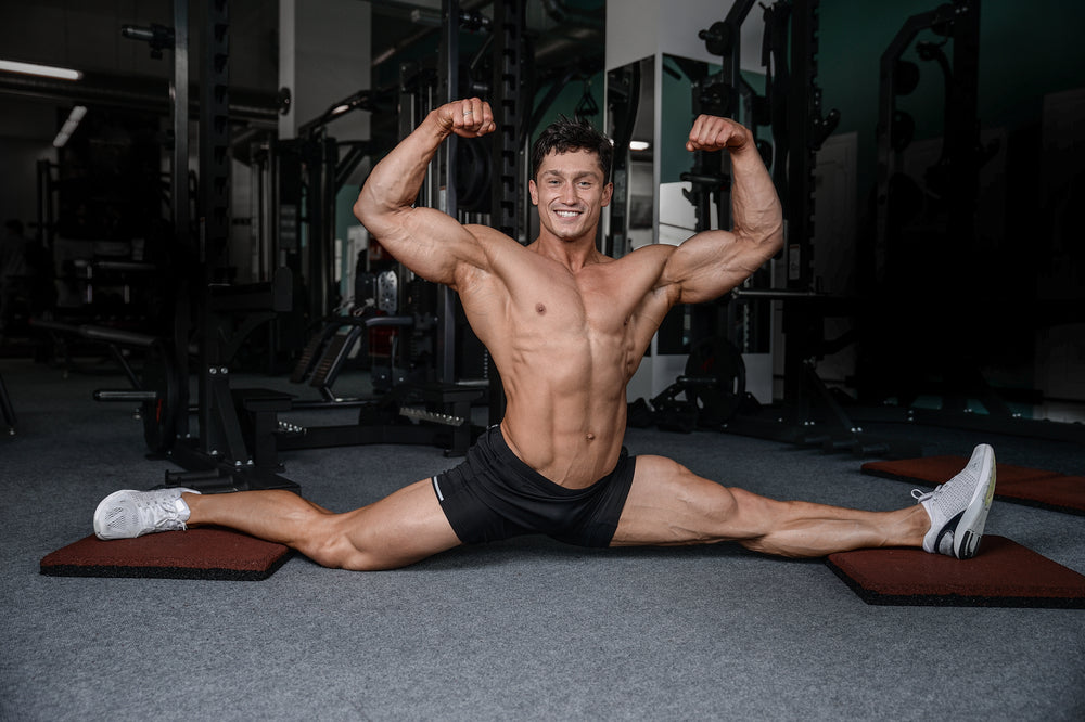 smiling man stretching legs in the gym