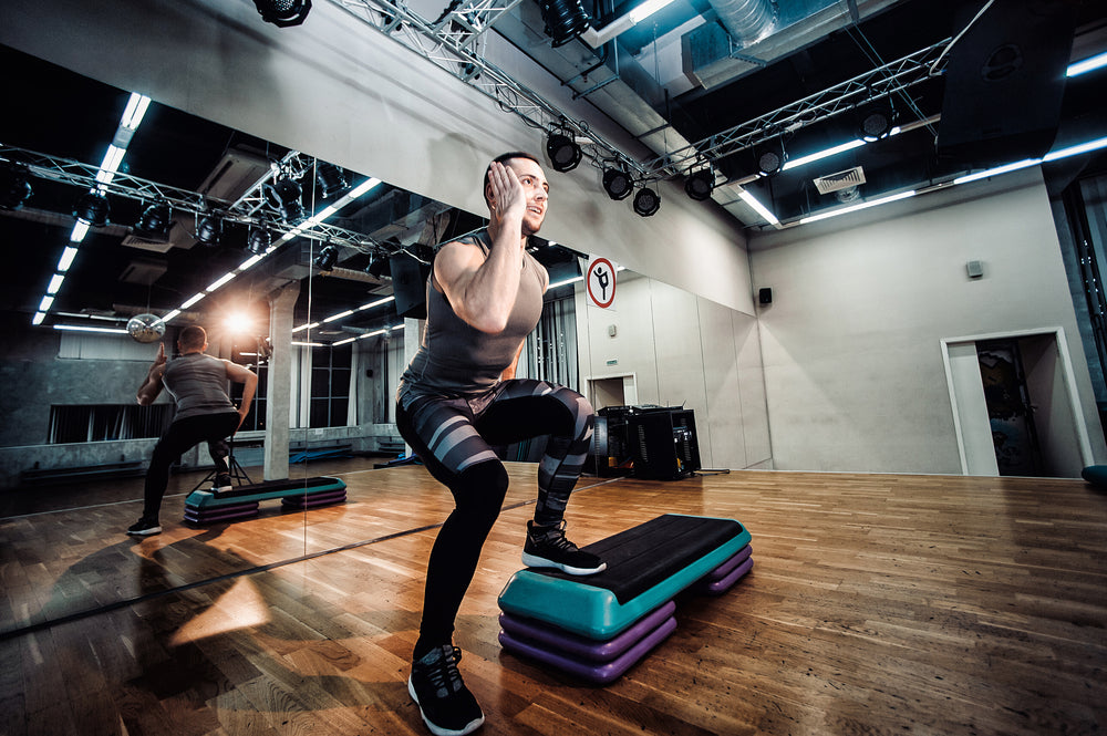 Man doing lateral step ups in health club