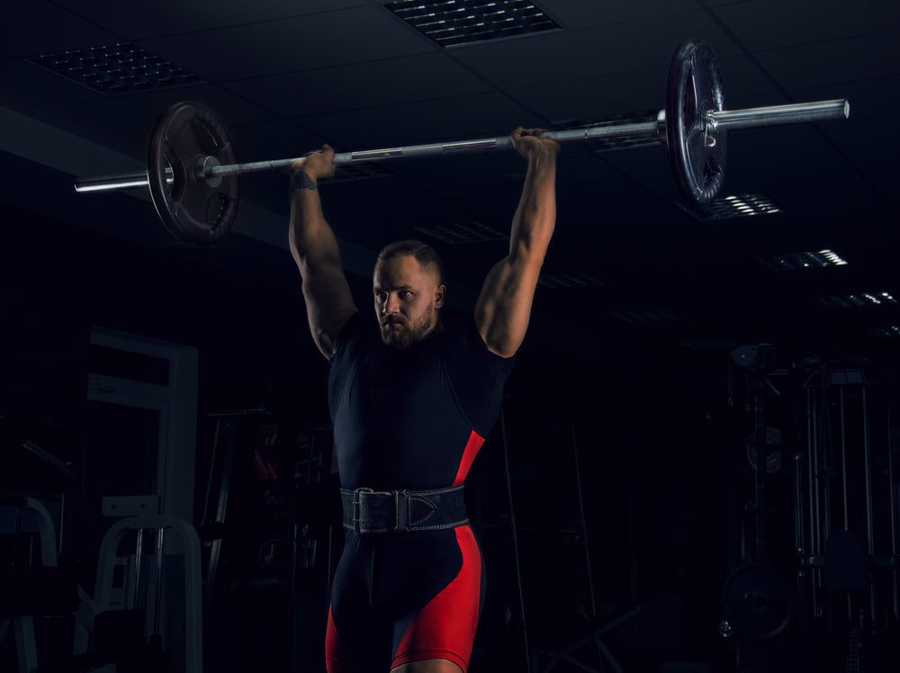 Weightlifter lifts the bar above his head