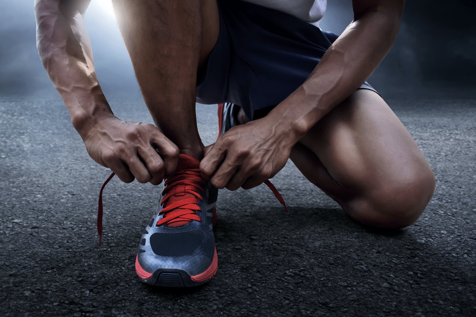 Dumbbells, sport shoes, smart phone with earphone, skipping rope and water bottle on wooden gym floor with word HIIT