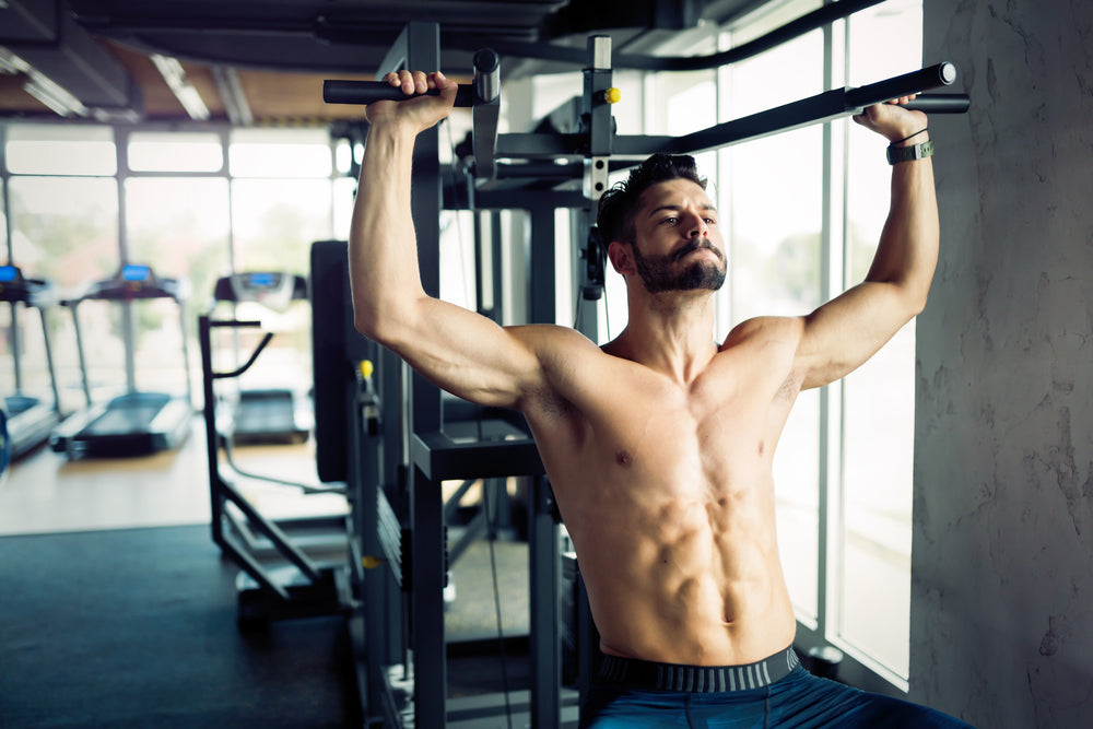 bodybuilder exercising on the shoulder press machine in a gym